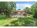 Spacious backyard featuring an in-ground pool, screened porch, and mature trees for privacy at 1134 Willow Oaks Trl, Matthews, NC 28104