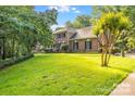 Charming two-story brick home with lush green lawn, mature trees, and classic architectural details at 1134 Willow Oaks Trl, Matthews, NC 28104
