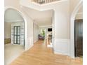 Spacious foyer featuring hardwood floors, arched doorways, and decorative wainscoting at 1147 Anduin Falls Dr, Charlotte, NC 28269