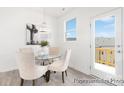 Cozy dining area boasts bright light, contemporary chandelier, glass top table, and deck access at 11716 Avocet Dr # 75, Charlotte, NC 28215