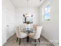 Cozy dining area features a contemporary chandelier, glass top table, and bright light at 11716 Avocet St # 75, Charlotte, NC 28215