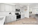 Bright kitchen features white cabinets, stainless steel appliances, white countertops, and wood look floors at 11716 Avocet Dr # 75, Charlotte, NC 28215
