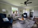Bright living room features hardwood floors, neutral walls, large windows and comfortable seating at 134 Snowbird Loop, Statesville, NC 28625