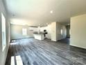 Bright, open-concept living room and kitchen featuring sleek laminate flooring, white kitchen cabinets, and ample natural light at 139 Dove Creek Trl, Statesville, NC 28625