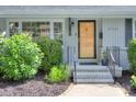 Close up of front door with brick accents and a manicured garden at 1715 Wensley Dr, Charlotte, NC 28210