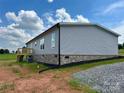 View of home with gray siding and brick foundation, set on a gravel driveway at 188 Trivette Rd, Harmony, NC 28634