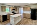 Modern kitchen with stainless steel appliances, center island, and wood-look flooring at 188 Trivette Rd, Harmony, NC 28634