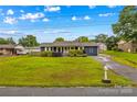 Quaint single story home with well-maintained landscaping, blue siding, and a long driveway at 211 Ridgecrest St, Kannapolis, NC 28081