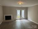 Bright living room showcasing a fireplace and doors that lead to a patio area at 2958 Iron Gate Ln, Charlotte, NC 28212