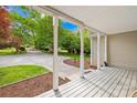 Covered front porch features white pillars and views of the landscaped front yard at 4120 Lake Shore S Rd, Denver, NC 28037