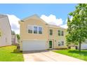Charming two-story home with light yellow siding, white trim, attached garage, and a lush lawn at 4521 Palustris Ct, Charlotte, NC 28269