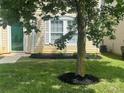 Well-manicured front yard with lush grass, a neatly mulched tree, and charming landscaping details at 4521 Palustris Ct, Charlotte, NC 28269