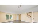 Inviting living room features gray wood-look floors, a staircase, and natural light at 4521 Palustris Ct, Charlotte, NC 28269