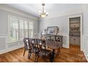 Traditional dining room showcasing hardwood floors, plantation shutters, elegant furniture, and ample natural light at 6211 Cruden Bay Way, Charlotte, NC 28277