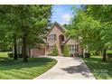 Elegant brick home featuring a spacious three-car garage and lush, green landscaping, with manicured lawn at 6211 Cruden Bay Way, Charlotte, NC 28277