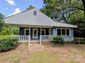 Inviting single-story home boasts light blue siding, white trim, covered front porch, and lush green landscaping at 647 Mckay Hill Rd, Mount Gilead, NC 27306