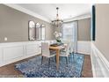 Formal dining room featuring classic wainscoting, an elegant chandelier, and a stylish rug, perfect for hosting gatherings at Lot 003 Bozeman Ct # 3, Stanley, NC 28164
