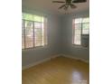 The bedroom with a ceiling fan features wood floors, two windows, and neutral paint to complement personal decor at 1121 Myrtle Ave # 58, Charlotte, NC 28203