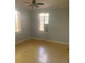 The bedroom with a ceiling fan features wood floors, two windows, and neutral paint to complement personal decor at 1121 Myrtle Ave # 58, Charlotte, NC 28203