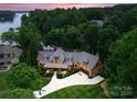 Breathtaking aerial view of lakeside home surrounded by lush greenery with lake access and manicured lawn at 116 Creeky Hollow Dr, Mooresville, NC 28117