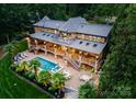 Gorgeous backyard showcasing a stunning pool, tiered patios, and lush landscaping on a private lot at 116 Creeky Hollow Dr, Mooresville, NC 28117
