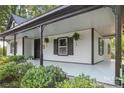 Welcoming front porch with plants, dark accents and a light painted floor and ceiling at 118 Cabarrus W Ave, Concord, NC 28025