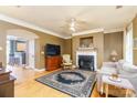 Inviting living room featuring hardwood floors, a fireplace, and a ceiling fan for added comfort at 123 Singleton Rd, Mooresville, NC 28117