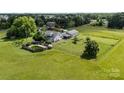 Aerial view of home with above ground pool and outbuildings in a private, rural setting at 18070 Old Beatty Ford Rd, Gold Hill, NC 28071