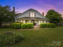 Charming two-story home featuring a covered front porch and meticulously maintained landscaping at 18070 Old Beatty Ford Rd, Gold Hill, NC 28071