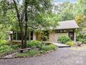 Charming exterior with stone accents, a wooden bridge walkway, and lush greenery enhancing its natural appeal at 218 Point Carpenter Rd, Fort Mill, SC 29707
