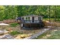 Charming elevated home with wood deck, stone pathway, and wooded surroundings at 295 Rendleman Rd, Salisbury, NC 28146
