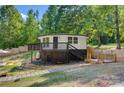 Charming elevated home with wood deck, stone pathway, and wooded surroundings at 295 Rendleman Rd, Salisbury, NC 28146