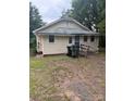 Rear of property shows exterior with a small deck and trashcans sitting outside at 343 Dayvault Sw St, Concord, NC 28025