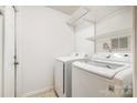 Bright laundry room with newer model washer and dryer and wire shelving at 3505 Frostmoor Pl, Charlotte, NC 28269