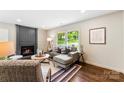 Comfortable living room with a dark fireplace, hardwood floors, and a bright window at 3661 Annlin Ave, Charlotte, NC 28209