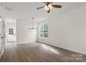 Bright living room with wood floors, elegant chandelier, and a large window at 5529 Seths Dr, Charlotte, NC 28269