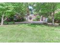Landscaped front yard with trees providing shade to the brick home and driveway at 625 Saint Andrews Rd, Statesville, NC 28625