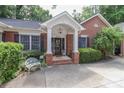 Close up of the entryway to the brick house, showcasing a bench and manicured bushes at 625 Saint Andrews Rd, Statesville, NC 28625