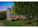 A beautiful two-story home with a covered front porch, set on a lush green lawn with mature trees at 6718 Heritage Orchard Way, Huntersville, NC 28078