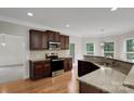 A modern kitchen boasts granite countertops, stainless steel appliances and dark wood cabinetry at 6718 Heritage Orchard Way, Huntersville, NC 28078