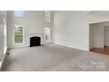 Bright and airy living room with a cozy fireplace, soaring ceilings and neutral carpeting at 6718 Heritage Orchard Way, Huntersville, NC 28078