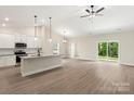 Open-concept kitchen features white cabinets, granite countertops, stainless steel appliances, and hardwood floors at 7121 Jerimoth Dr, Charlotte, NC 28215