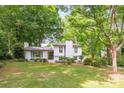 Inviting two-story home featuring a brick exterior, lush lawn, and mature shade trees at 7123 Linda Lake Dr, Charlotte, NC 28215