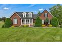 Beautiful brick home with manicured landscaping and inviting front porch at 814 Settlers Dr, Cherryville, NC 28021
