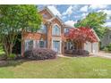Charming brick home with blue shutters, a well-maintained lawn, and mature trees at 9710 Holden Ct, Charlotte, NC 28277