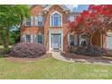 Inviting front entrance of a brick home with charming landscaping and blue shutters at 9710 Holden Ct, Charlotte, NC 28277