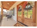 Inviting front porch with double doors adorned with decorative wreaths and comfortable seating at 1134 Fincher Rd, Fort Lawn, SC 29714