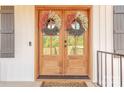Close-up of an inviting front door, beautifully decorated with decorative wreaths and natural wood finish at 1134 Fincher Rd, Fort Lawn, SC 29714