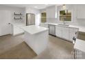 Modern kitchen featuring white cabinets, stainless steel appliances, a center island, and bright lighting at 1212 Beechdale Dr, Charlotte, NC 28212