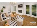 Bright living room featuring hardwood floors, fireplace, and French doors to the backyard at 1212 Beechdale Dr, Charlotte, NC 28212
